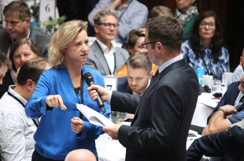 Dame taler i mikrofon under et debatmøde