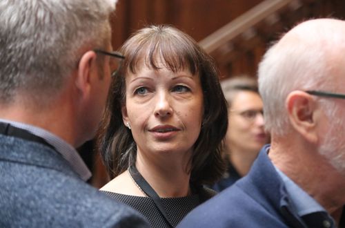 Karen Friss Bach står sammen med flere personer og snakker til debatmødet