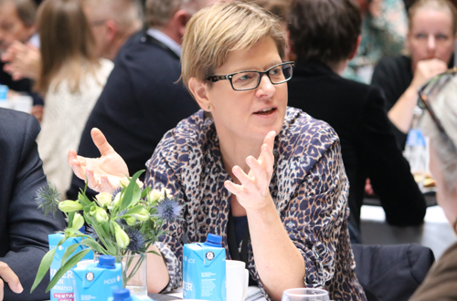 Ulla sidder og drøfter forskellige ting ved sit bord under debatmøde