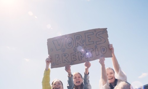 3 piger holder et skilt med teksten "Vores fremtid"